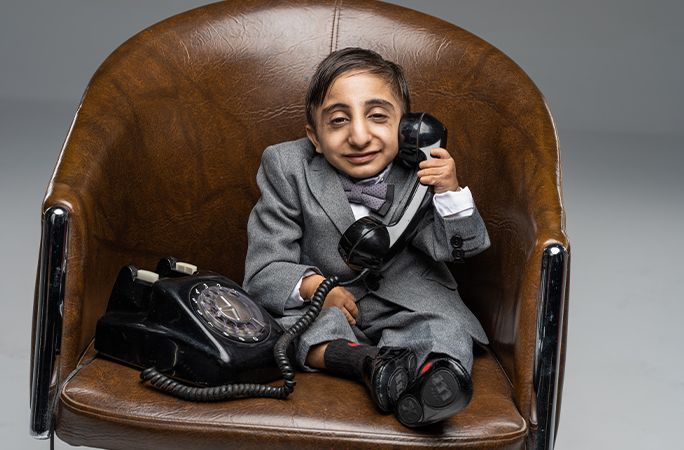 World shortest man sitting on a chair holding a phone tcm28 730189.jpg